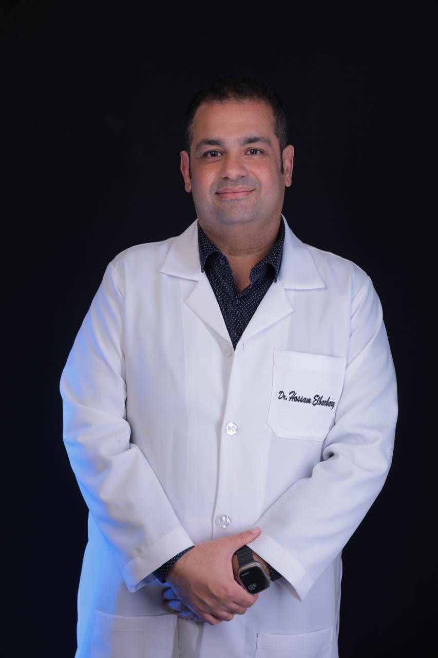Dr. Hossam Elbarbary, Consultant Ophthalmologist and Eye Surgeon in Dubai, wearing a white medical coat and smiling confidently.